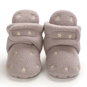 Detailed view of cozy mauve baby booties featuring gold star embroidery and soft plush lining