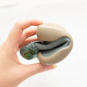 Nahaufnahme der Flexibilität eines Kleinkindsockenschuhs mit weicher Gummisohle.
