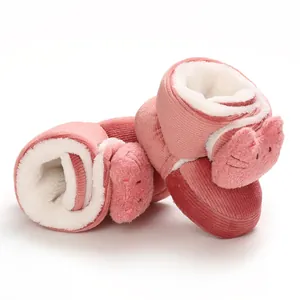 Primer plano de zapatos de algodón rosa para bebés con cara de gato y forro suave