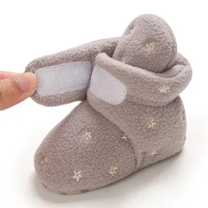 Detailed macro view of grey fleece baby snow boot with Velcro closure and star embroidery