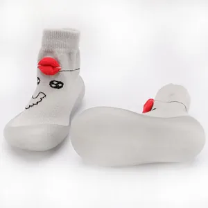 Close-up of soft-soled baby walking shoes with cartoon face and red lip design