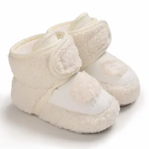 Dettaglio degli stivaletti da neve per neonati in sherpa color crema con suola morbida calda