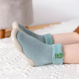 Detailansicht der dicken Winter-Babysocken-Schuhe mit niedlicher Dinosaurier-Stickerei