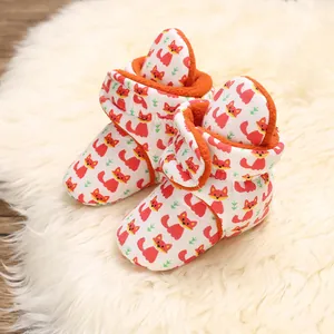 Close-up of cozy baby cotton booties featuring a cute red fox pattern on white fabric