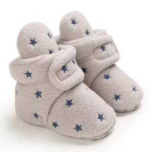 Detail of soft fleece baby winter boots with navy star embroidery and velcro.