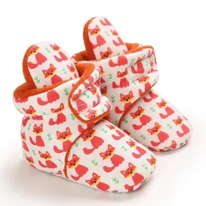 Close-up of baby cotton shoes featuring cute fox pattern and soft orange fleece lining.