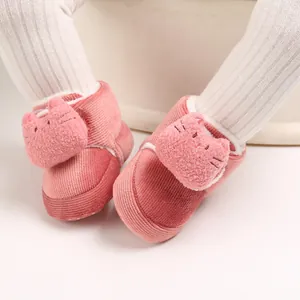 Detalle de zapatos de bebé en pana rosa con gato de peluche para niños de 0 a 1 año