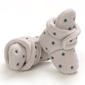 Close-up detail showing soft fleece texture and blue star patterns on baby snow boots