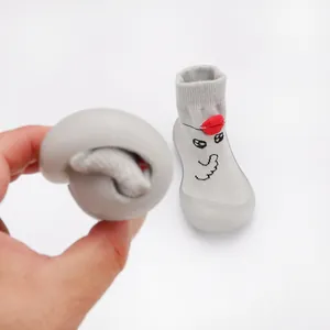 Close-up showing the extreme flexibility of grey cartoon baby soft sole walking shoes