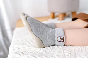 Detailansicht grauer Baby-Wintersocken-Schuhe mit warmem Lammfellfutter und Eulen-Stickerei.