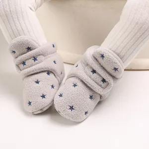 Close-up view of baby snow boots featuring soft fleece texture and blue star embroidery