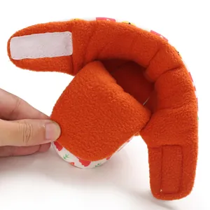 Close-up detail of warm orange fleece lining and velcro closure in infant baby shoes