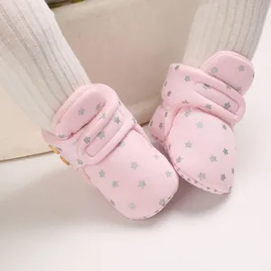 Primer plano de botas de nieve rosas para bebé con estrellas, forro polar suave y velcro