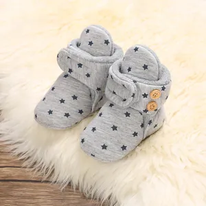 Detalle de botas de invierno para bebé grises con patrón de estrellas y forro polar