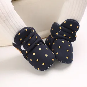 Primer plano de botas de nieve para bebé azul marino con estrellas doradas y velcro