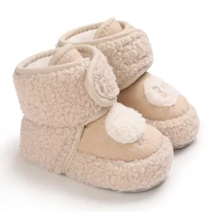 Dettaglio di stivaletti neonato in pile beige con ricamo di agnello e chiusura velcro