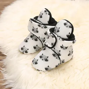 Close-up of soft baby booties with cute raccoon pattern and warm black lining