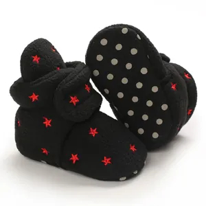 Detail view of warm black baby booties with red star embroidery and anti-slip dots