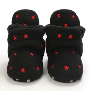 Detailed view of warm black baby boots with red embroidered stars and soft sole.