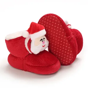 Detalle de los patucos de invierno rojos para bebé con diseño de Papá Noel y suela de goma.