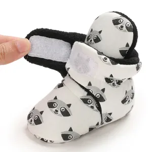 Close-up view of the white velcro strap closure on cute raccoon pattern baby winter booties