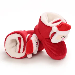 Detalle del forro polar de felpa y diseño de Papá Noel en botas rojas de invierno para bebé.