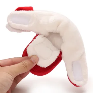 Detalle de zapatos suaves de felpa para bebé con correas de velcro y forro cálido.
