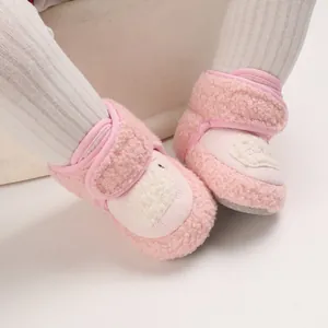Dettaglio di stivaletti da neve rosa in pile per neonati con viso di animale e velcro