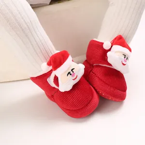 Primer plano zapatos de pana rojos para bebé con lindo diseño de Papá Noel 3D de invierno