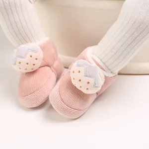 Detalle de zapatos de pana rosa para bebés con un lindo parche de fresa animada