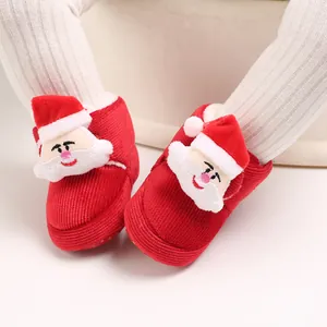 Primer plano de zapatos de invierno para bebé en pana roja con lindo Papá Noel 3D de felpa