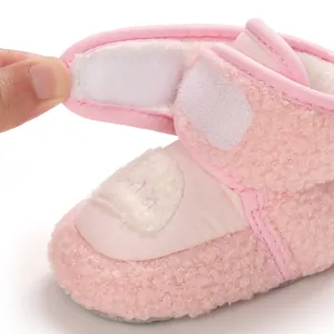 Dettaglio della chiusura a strappo su stivaletti rosa per neonati con fodera in peluche