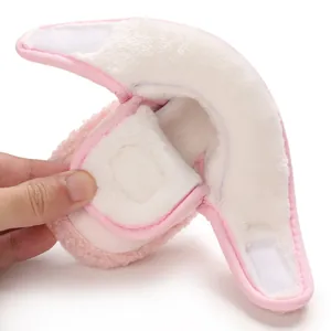 Dettaglio dell'imbottitura in pile bianco nelle scarpe invernali rosa per neonati.