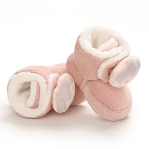 Primer plano de botas rosas para bebé en pana con forro de felpa y diseño animal