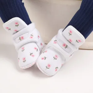 Nahaufnahme weißer Babyhausschuhe mit Blumenstickerei und warmem Fleece-Innenfutter