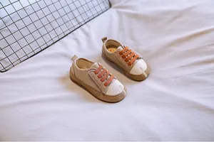 Detailansicht beiger Baby-Leinenschuhe mit orangen Riemen und Tabi-Split-Toe-Design