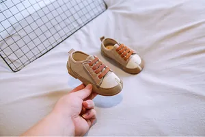 Detailansicht beige Baby-Leinenschuhe mit orangefarbenen elastischen Schnürsenkeln.