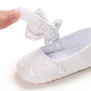 Nahaufnahme weißer Baby-Prinzessinnenschuh mit Klettverschluss und Herzstickerei