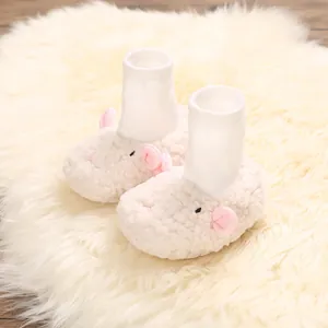 Detailed close-up view of cute sheep-shaped plush baby shoes on a soft faux fur rug