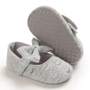 Detailansicht grauer Baby-Prinzessinenschuhe mit bestickten Herzen und Schleife