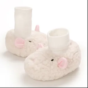 Close-up of soft white fleece baby booties with cute cartoon animal ears and face