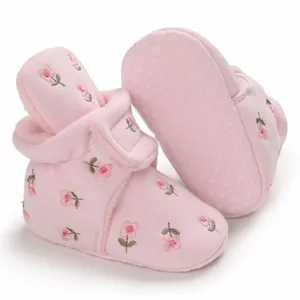 Detailansicht der rosa gefütterten Baby-Winterschuhe mit Blumenstickerei und weicher Sohle.
