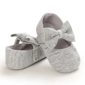 Detailansicht grauer Baby-Prinzessinnenschuhe mit Herzstickerei und Schleifen