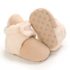 Primer plano de botas de invierno de felpa para bebé con suelas antideslizantes.