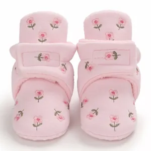 Detailansicht des weichen Fleecefutter und Stickerei auf rosa Baby-Winterschuhen.