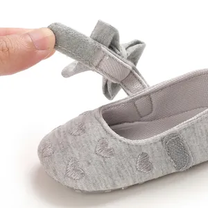 Detailansicht eines grauen Babyschuhs mit Klettverschluss und Herzstickerei für Kleinkinder.