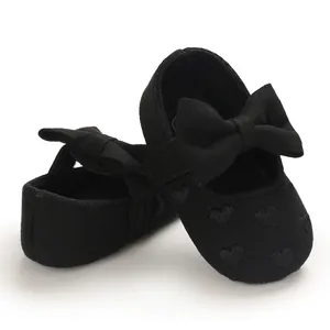 Detailansicht schwarzer Baby-Lauflernschuhe mit eleganter Schleife und Herz-Stickerei.
