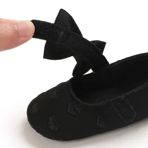 Nahaufnahme von schwarzen Baby-Prinzessin-Lauflernschuhen mit verstellbarem Klettverschluss.