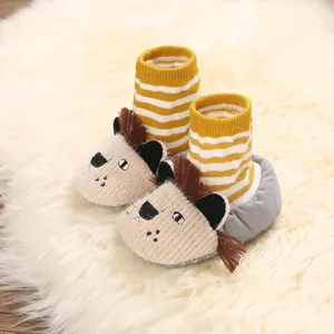 Close-up of cute cartoon lion baby shoes with warm striped knit socks and soft sole