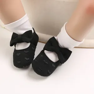 Detailansicht der schwarzen Baby-Prinzessin-Schuhe mit Herzstickerei und süßen Schleifen